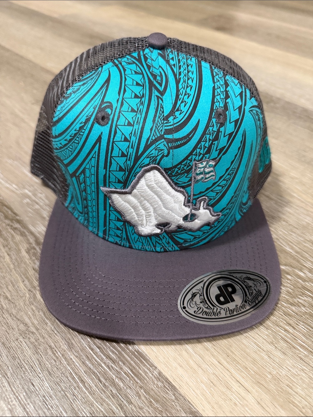 OGA Men’s Teal Pattern Trucker Hat with White Embroidered Logo